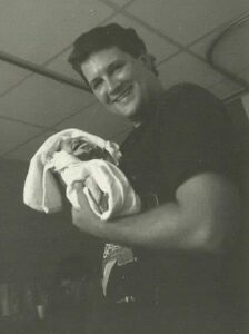 Pastor James holding his firstborn, James Matthew in 1995.